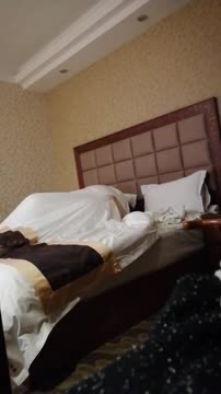 某明星冯XX床战土豪干爹13分钟影片泄露视频截图中的女子在酒店床上玩着手机